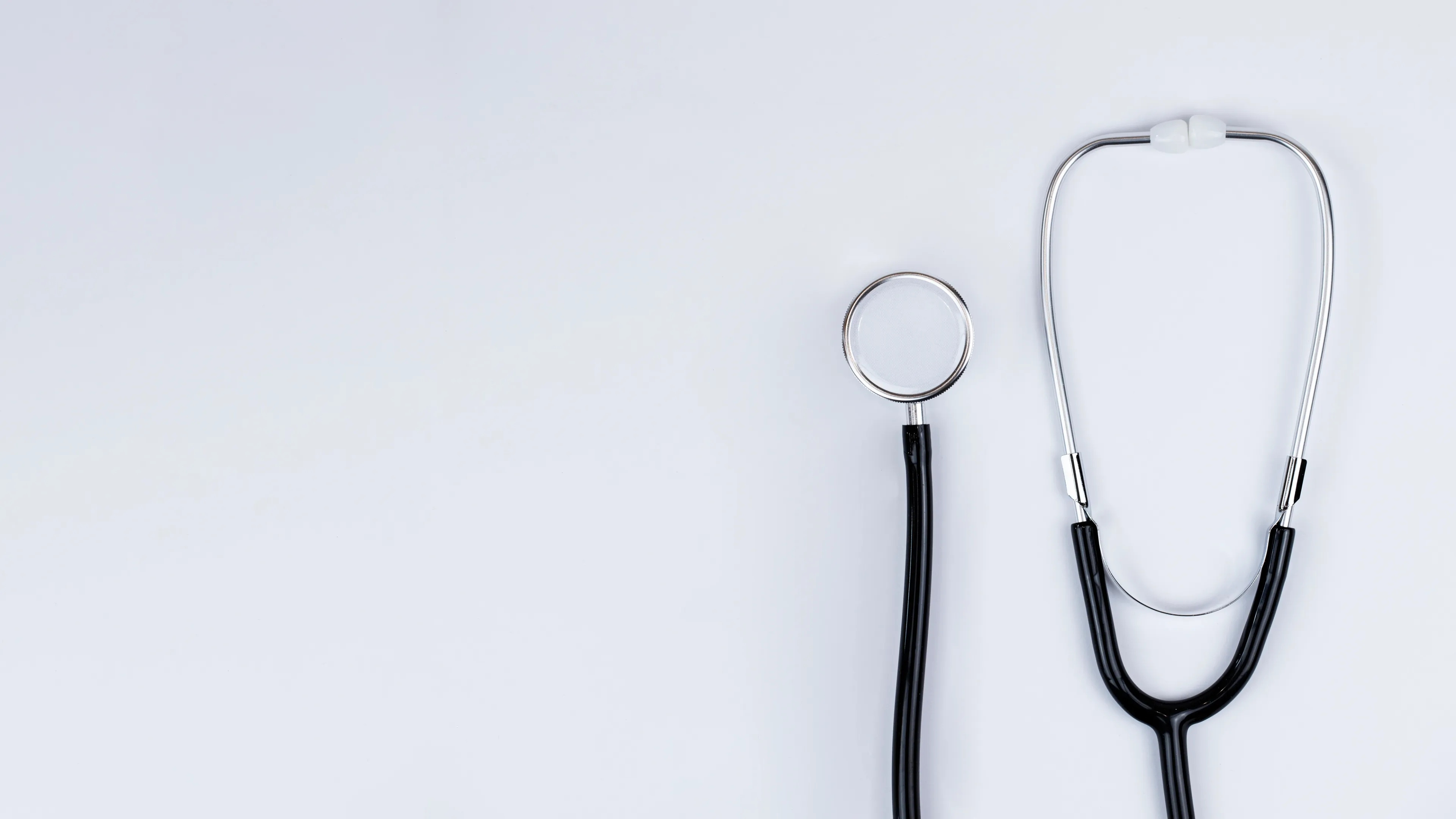 A stethoscope placed on a white background, symbolizing healthcare, medicine, or medical examination.