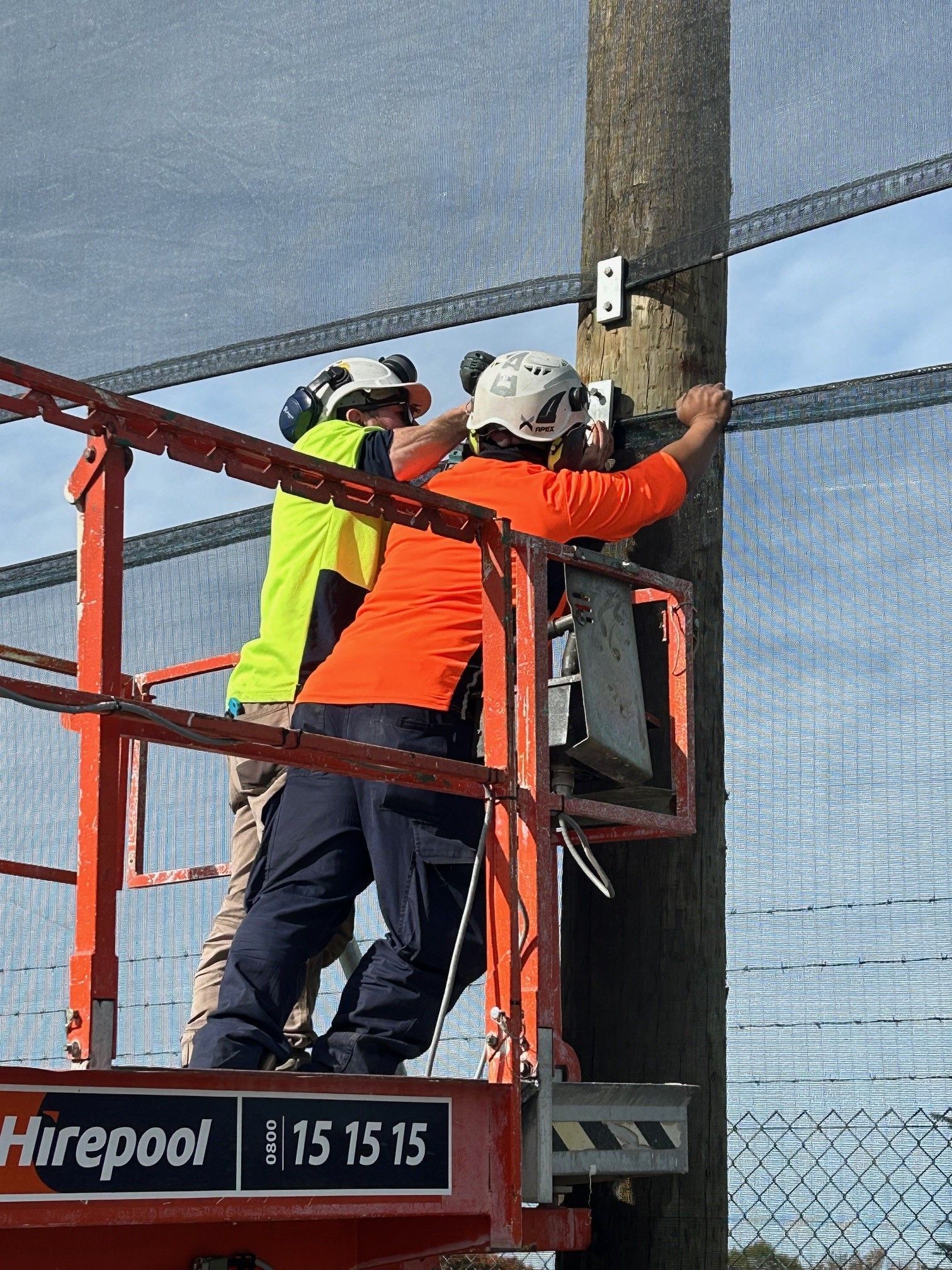 Safety workers in high-visibility gear installing fencing