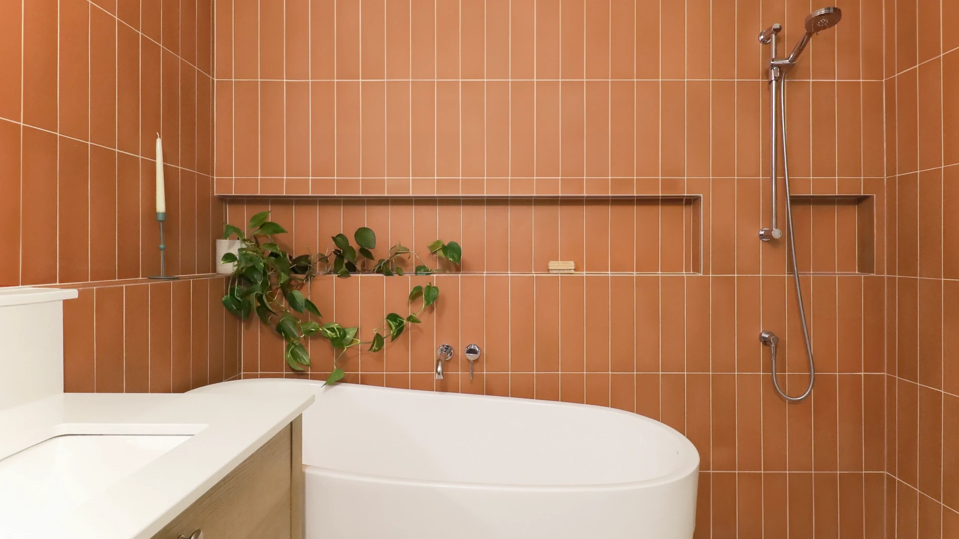 Salle de bain avec tuiles rectangles de couleur terra cotta, niches murales. Espace bain et douche à aire ouverte