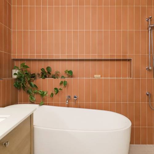 Salle de bain avec tuiles rectangles de couleur terra cotta, niches murales. Espace bain et douche à aire ouverte