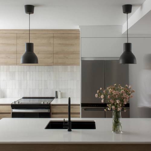 Cuisine moderne avec armoires en bois clair, luminaires noirs et plan de travail blanc, décoration minimaliste.