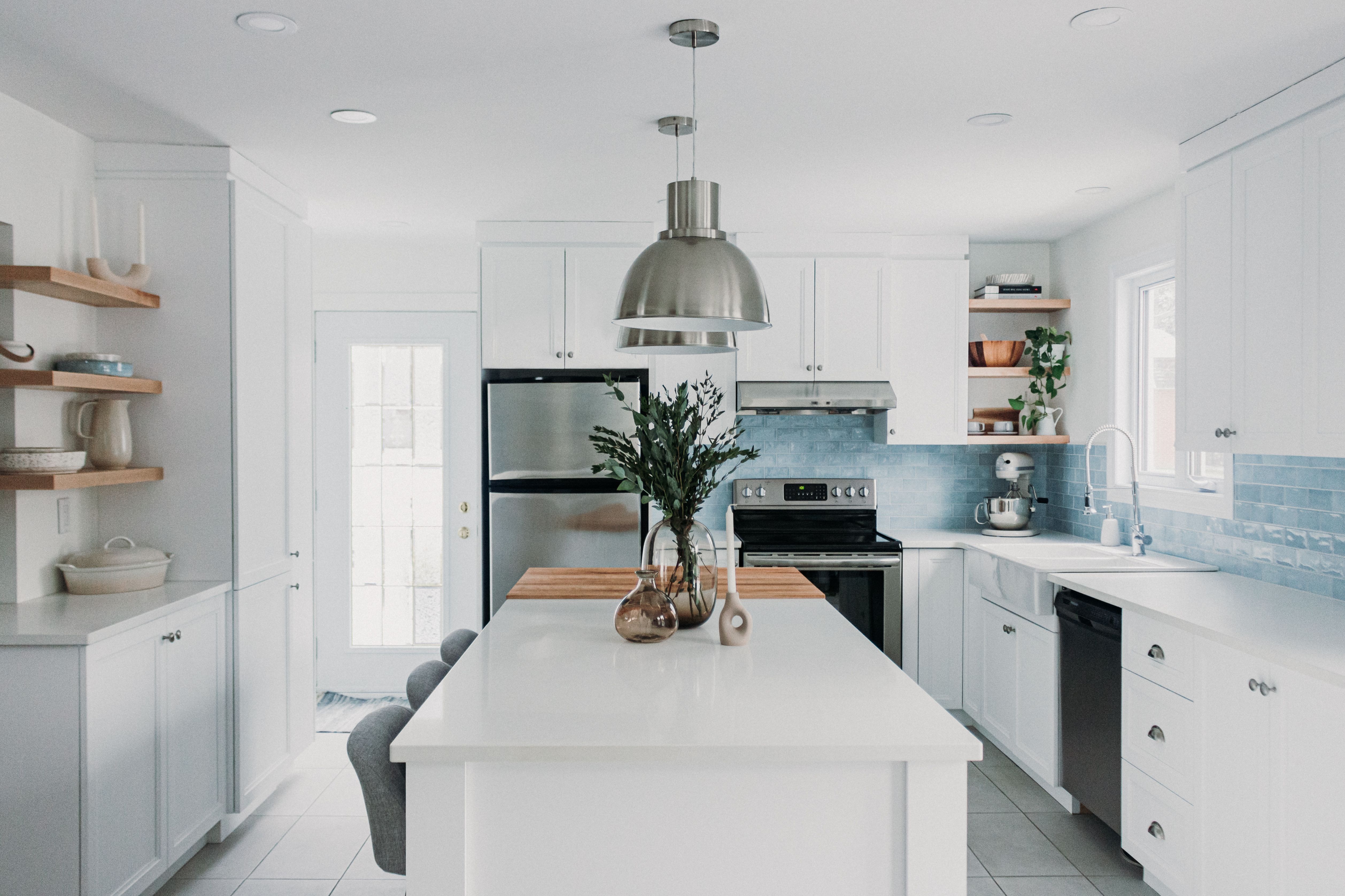 Cuisine blanche de style farmhouse avec dosseret de tuiles bleues et comptoir en bloc de boucher