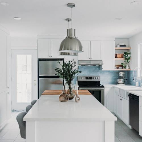 Cuisine blanche de style farmhouse avec dosseret de tuiles bleues et comptoir en bloc de boucher