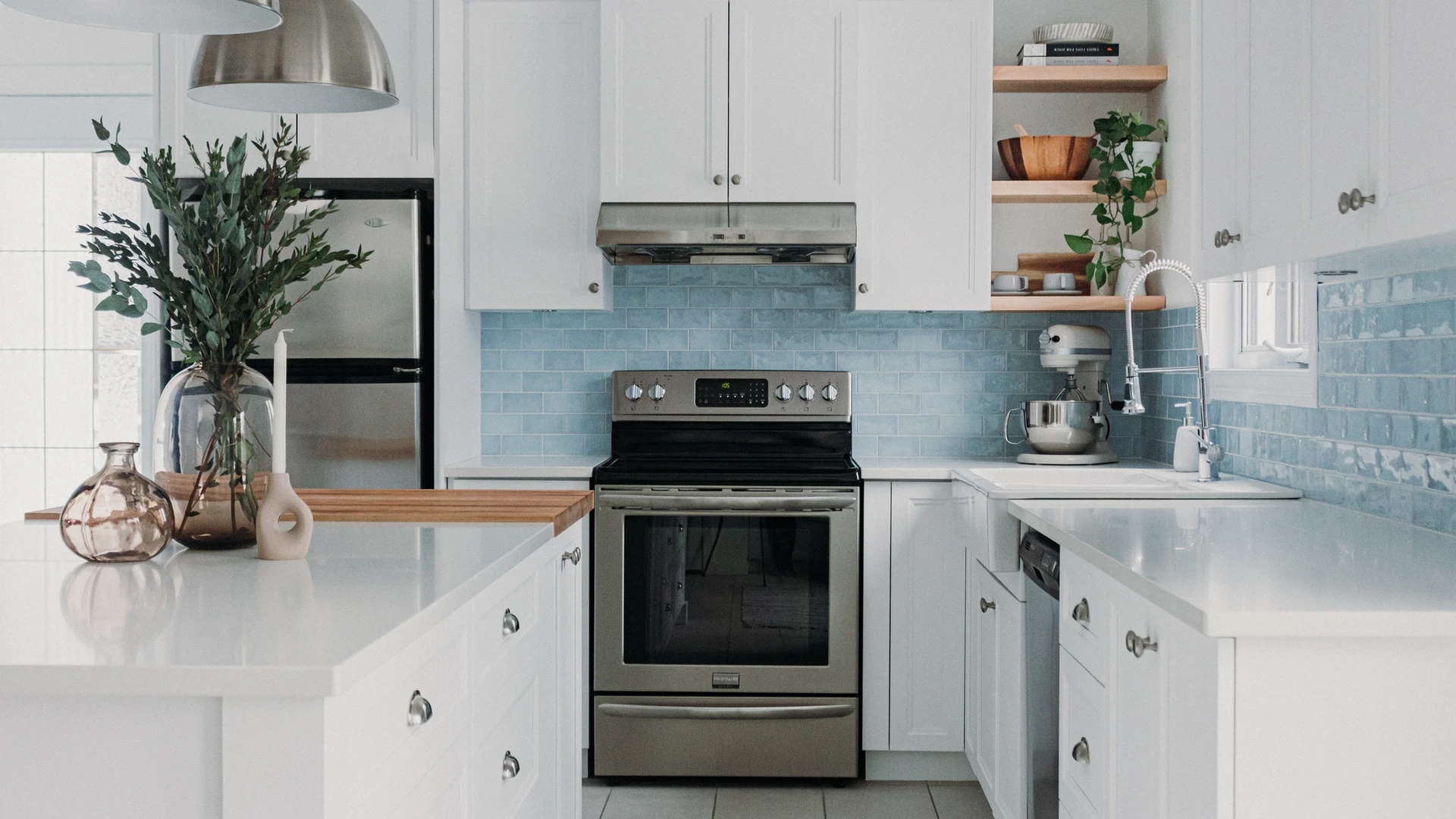 Cuisine blanche de style farmhouse avec dosseret de tuiles bleues et comptoir en bloc de boucher