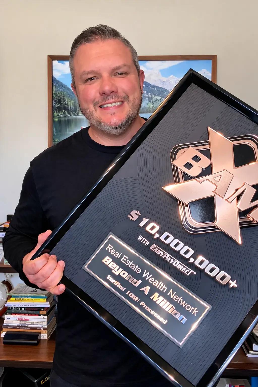 Real Estate Wealth Network founder holding a BAM X $10M+ award plaque