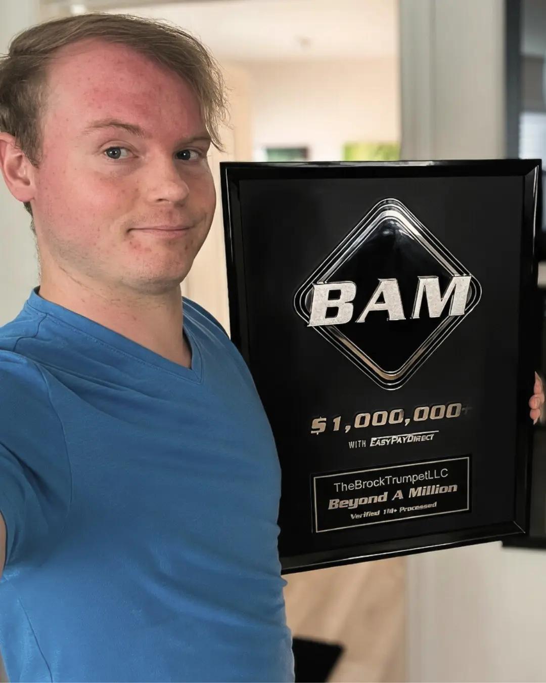 TheBrockTrumpetLLC founder holding a BAM $1M+ award plaque