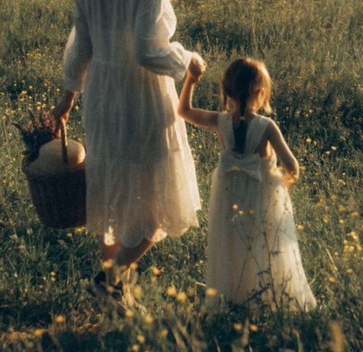 A toddler reaching up to touch her pregnant mother's belly in dappled sunlight