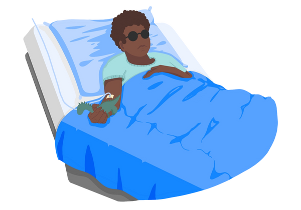 An illustration of a young boy reclining in a hospital bed. He has brown skin and dark brown, curly hair. He is holding a green toy dinosaur in his right arm, which also has an IV port in it. He is wearing round, black glasses, representing vision loss. His other arm rests across his chest. He is wearing a green shirt and is under a blue blanket. The pillow is a lighter blue, the sheets are white, and the frame is grey metal. The boy looks sickly and tired.