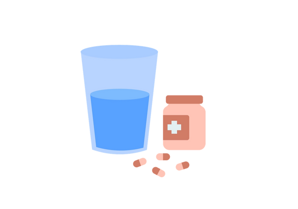 Une tasse d'eau et une bouteille de pilules