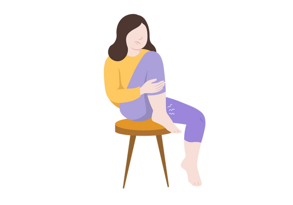 An illustration of a woman sitting on a stool with one foot on the floor and the other tucked against her chest with her heel on the stool. Her light peach-toned ankles are swollen, and three white squiggly lines come from the ankle resting on the stool. The frowning woman has medium length brown hair and is wearing a yellow sweatshirt and medium purple capri-length leggings.