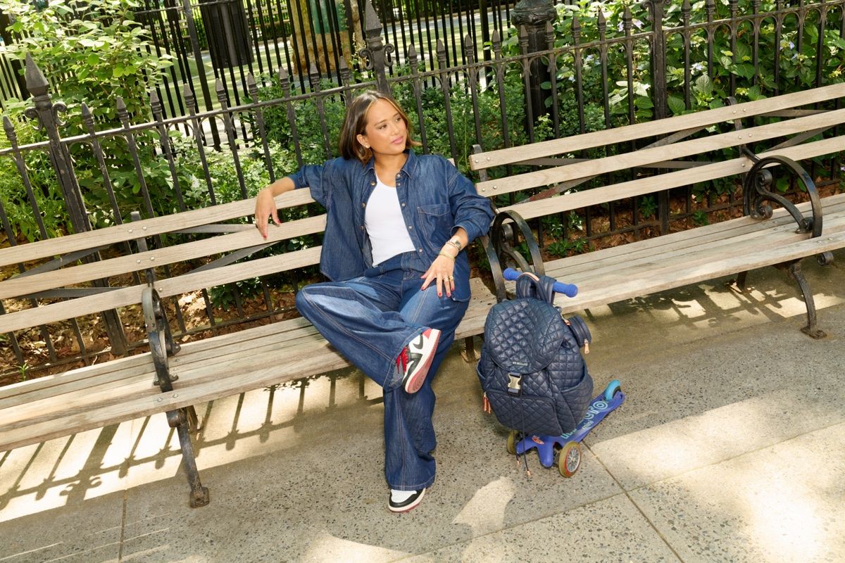 Jeanelle in denim on a park bench beside a stroller