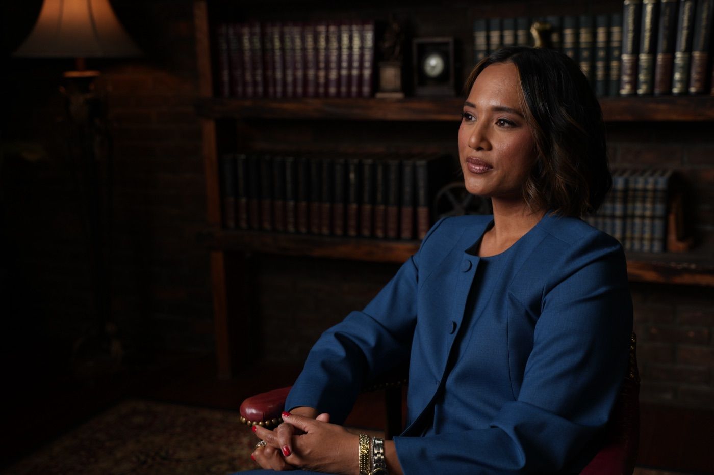 Jeanelle seated in a wood-panelled library