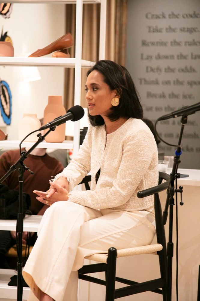 Jeanelle speaking into a microphone on a podcast panel