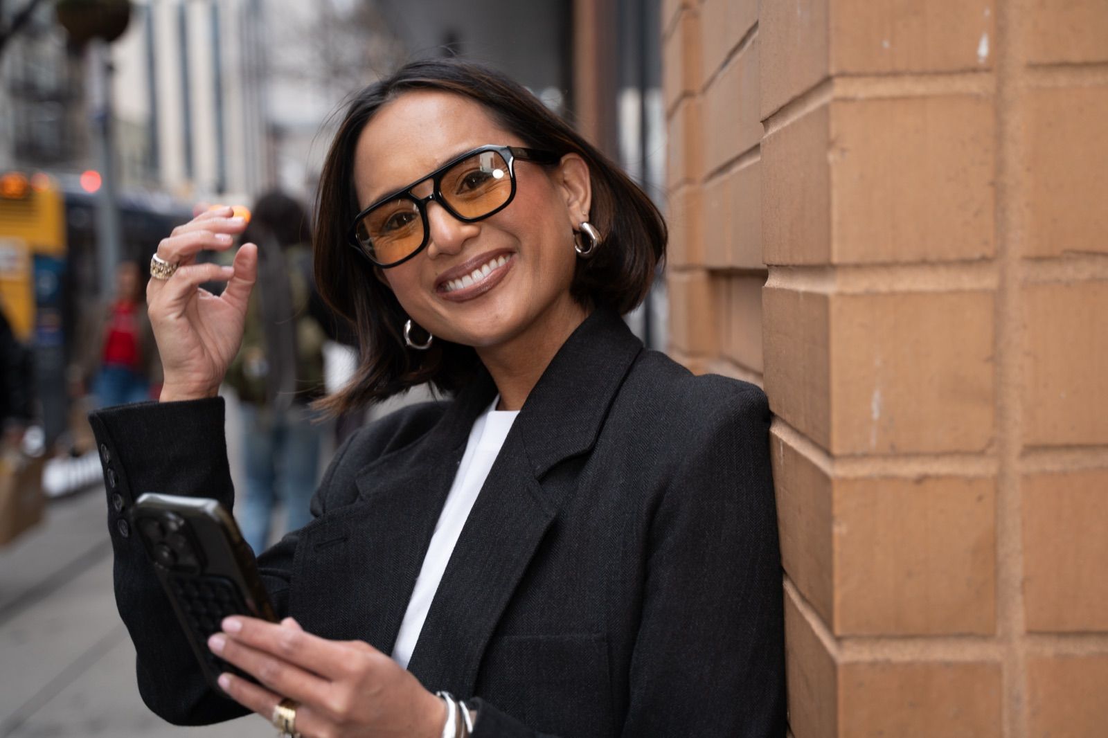 Jeanelle in a black blazer and glasses on a New York street