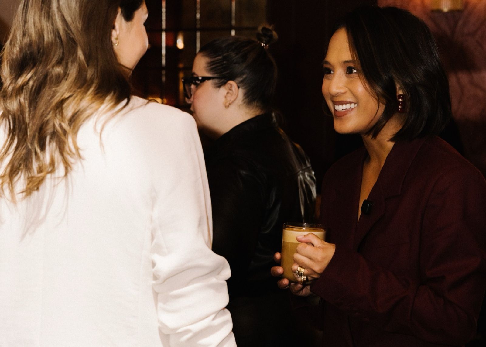 Jeanelle with a coffee, talking with guests after the fireside