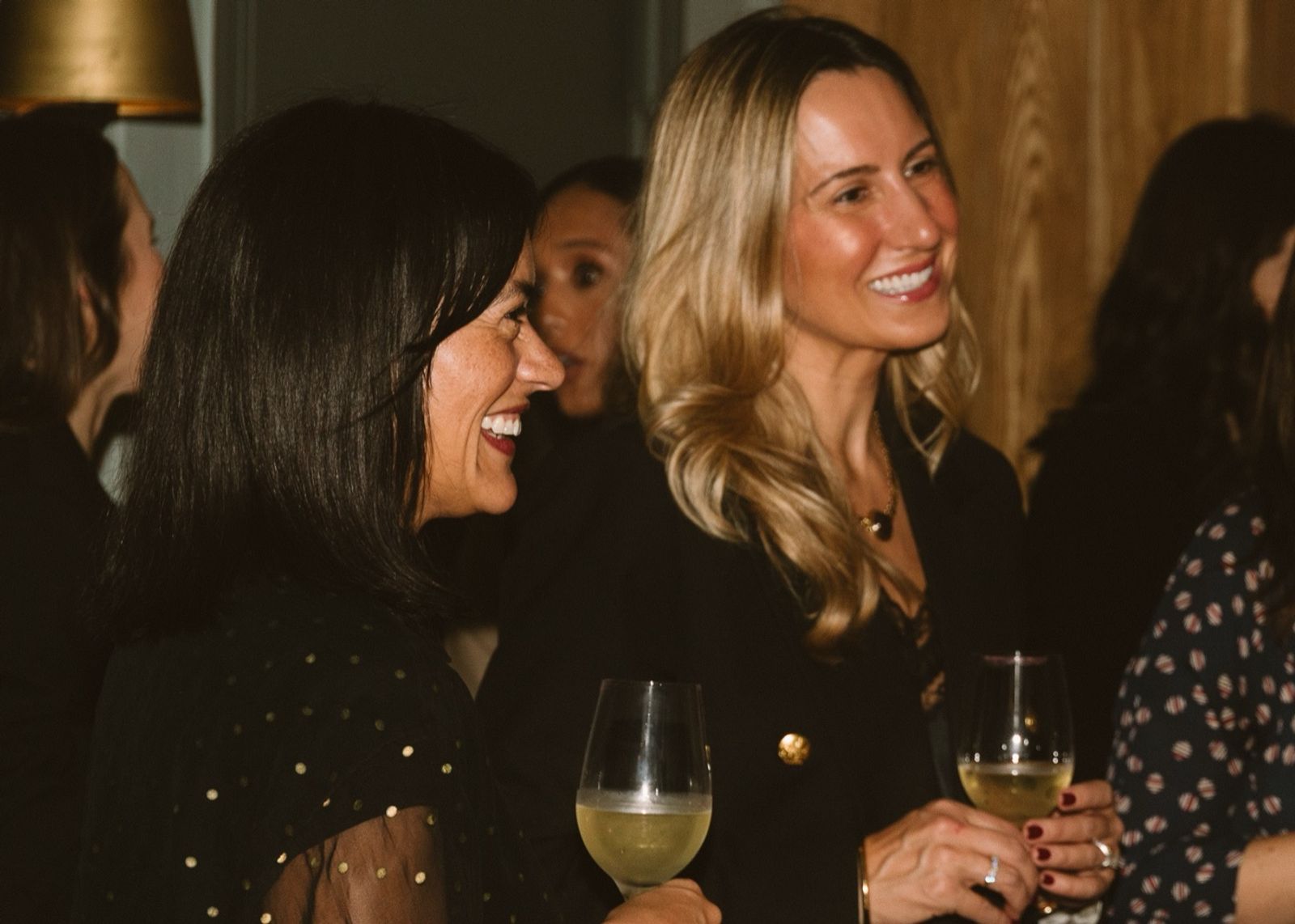 Two guests laughing over wine at the dinner