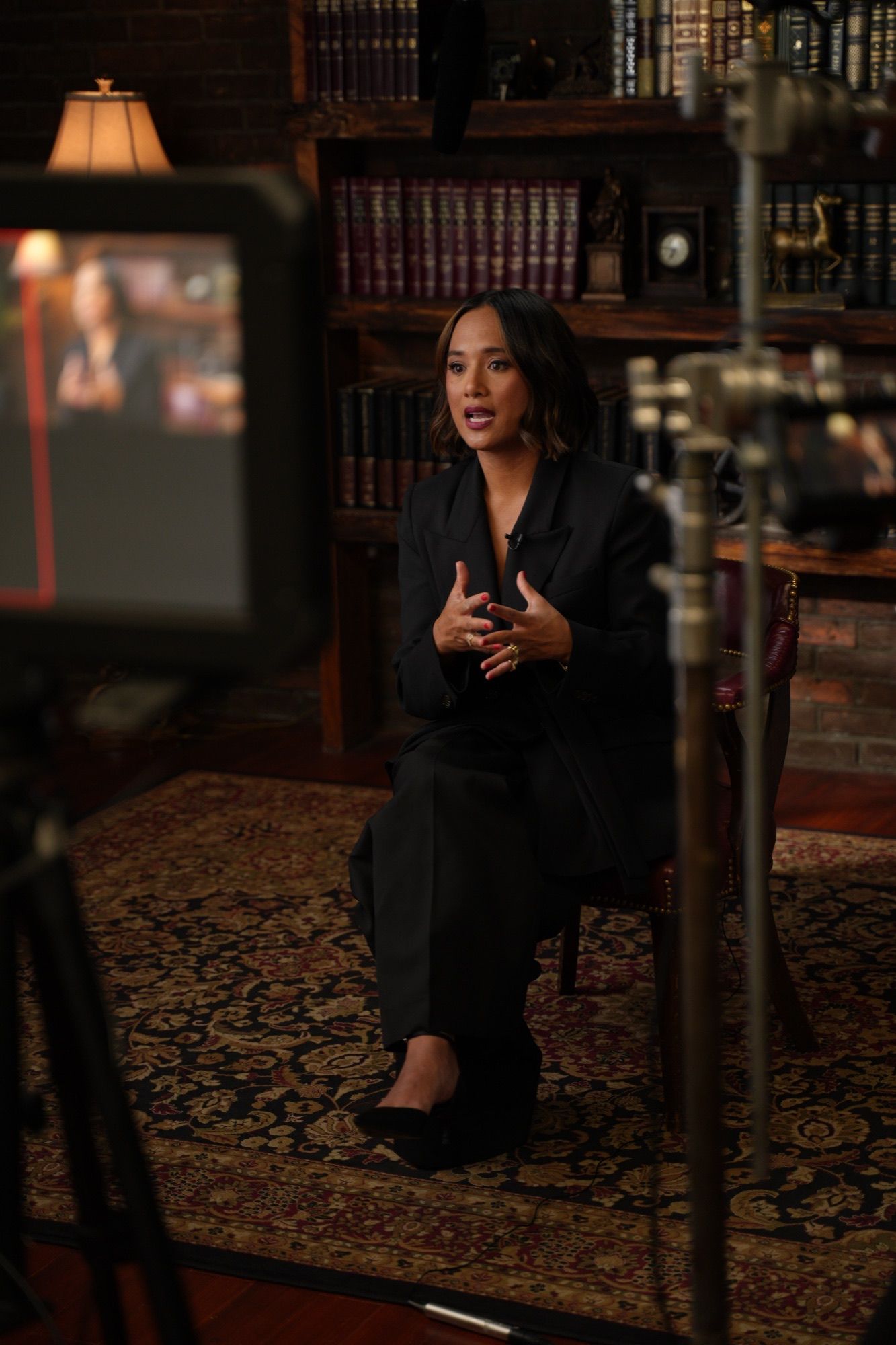 Jeanelle on set filming Work Lunch, camera monitor and lights in frame