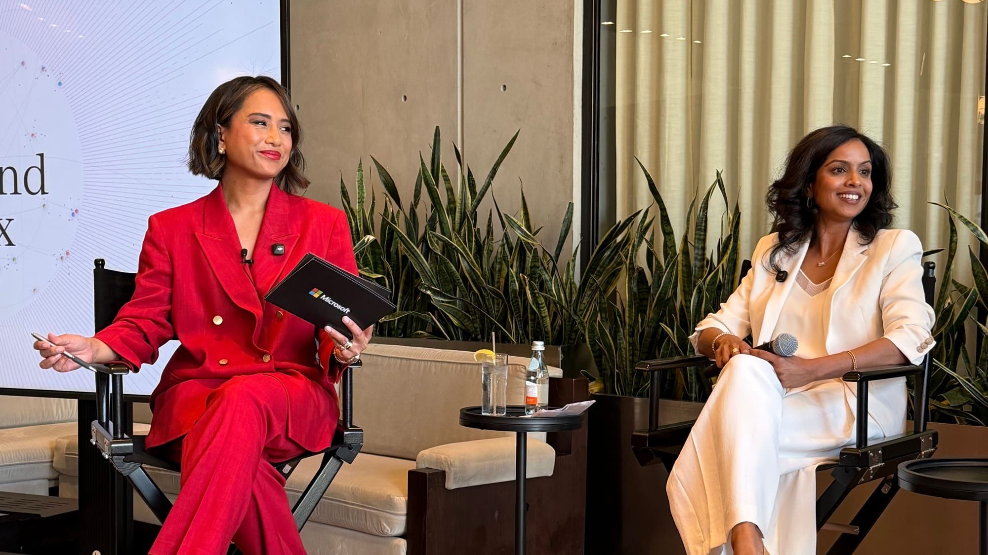 Jeanelle in a red suit on stage at the Work Trend Index launch in New York, in conversation with a panelist