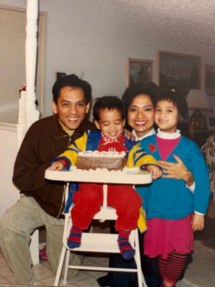 Jeanelle as a child with her family and a birthday cake