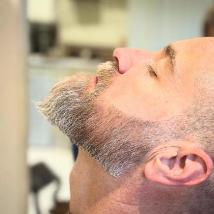 A client reclined for a beard sculpt