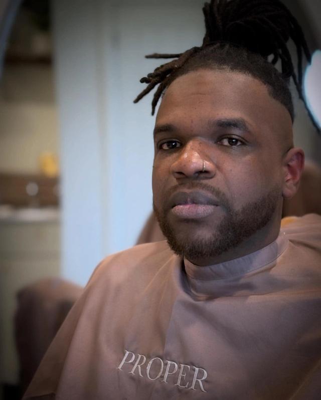 Locs with a clean fade and shaped beard