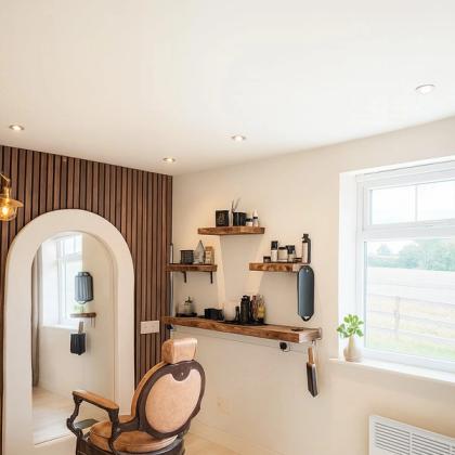 The studio’s arched mirror above a tan leather barber chair