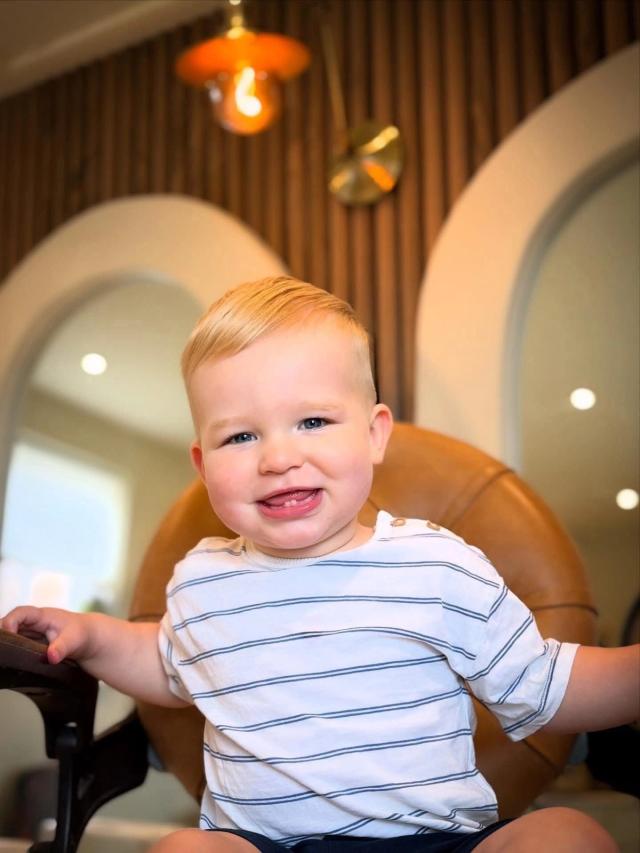 A young client smiling in the barber chair