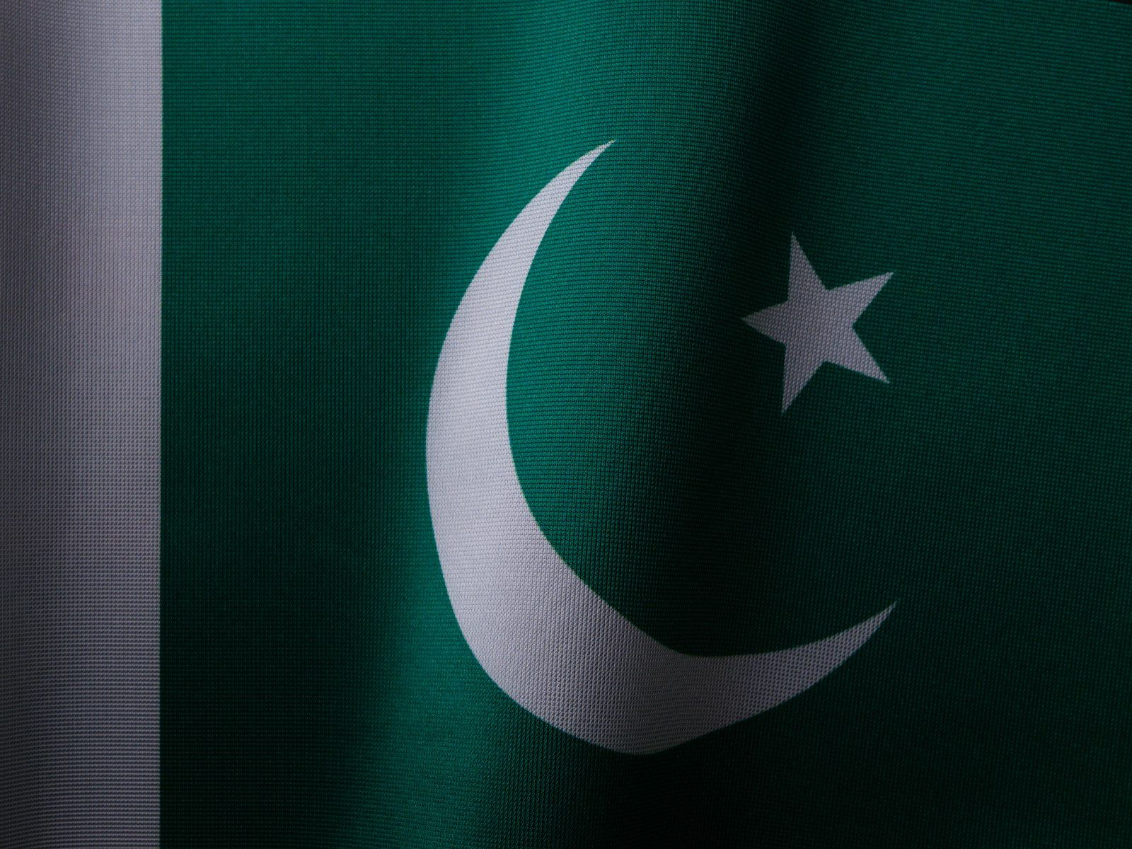 Close up of the flag of Pakistan, green with a white crescent and star