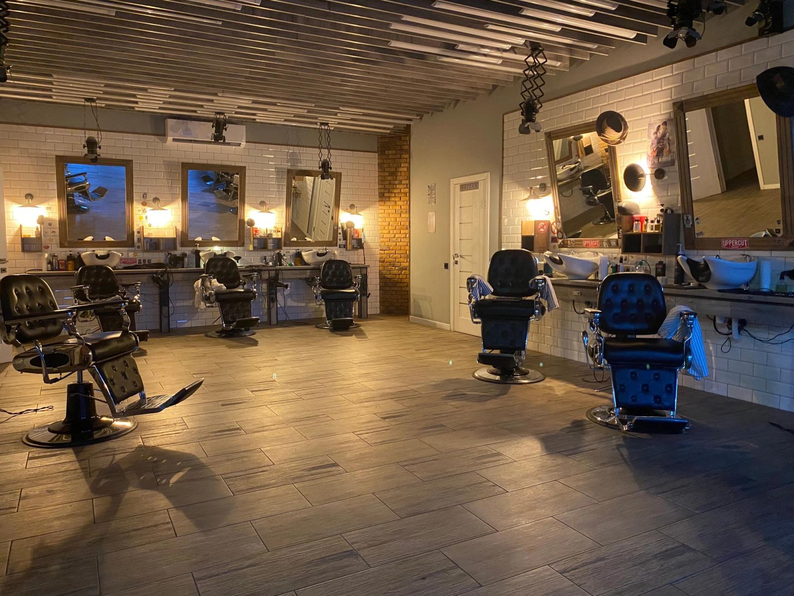 Empty barber chairs and mirrors in a men's grooming salon