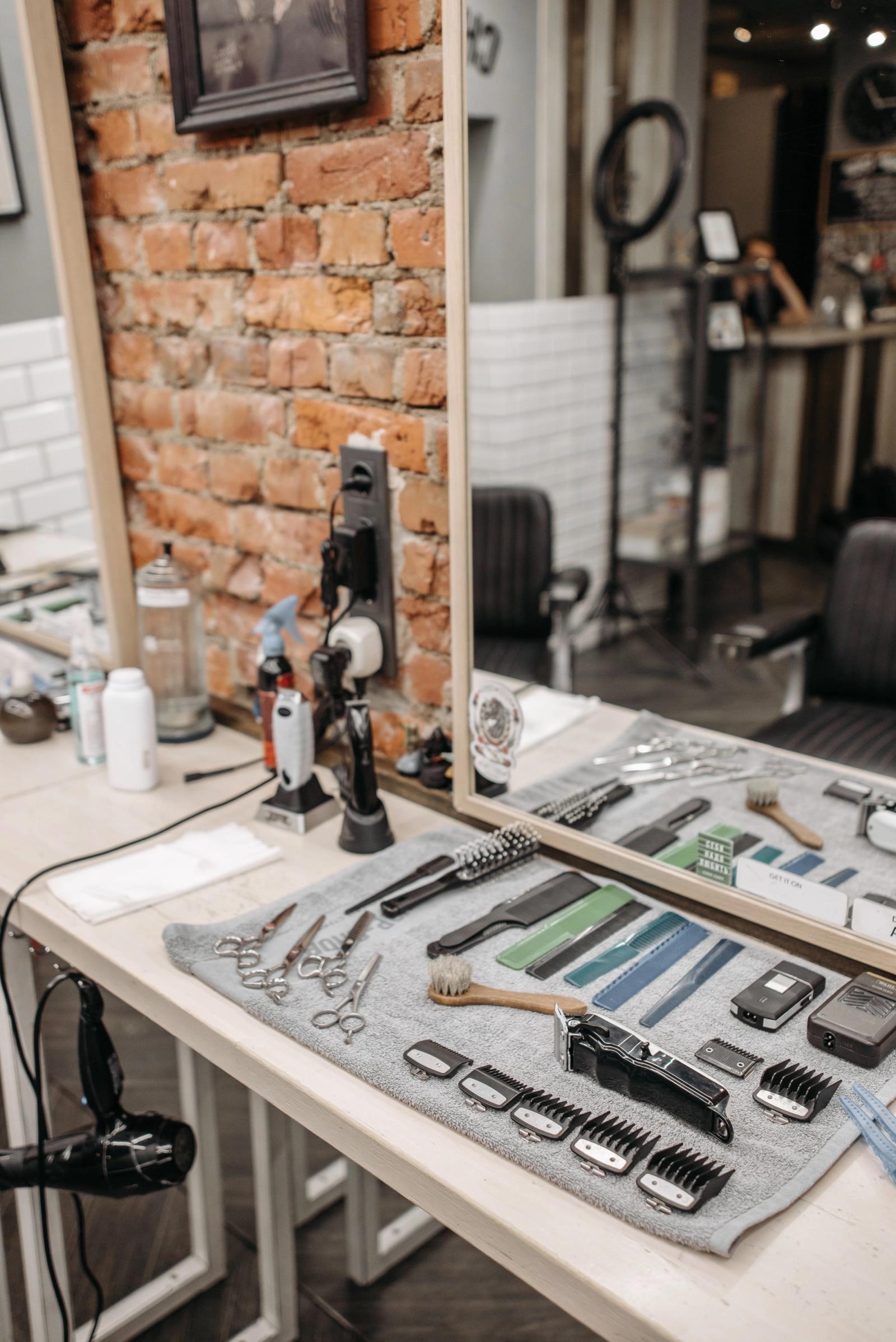 Barber tools laid out neatly on a shelf against a brick wall