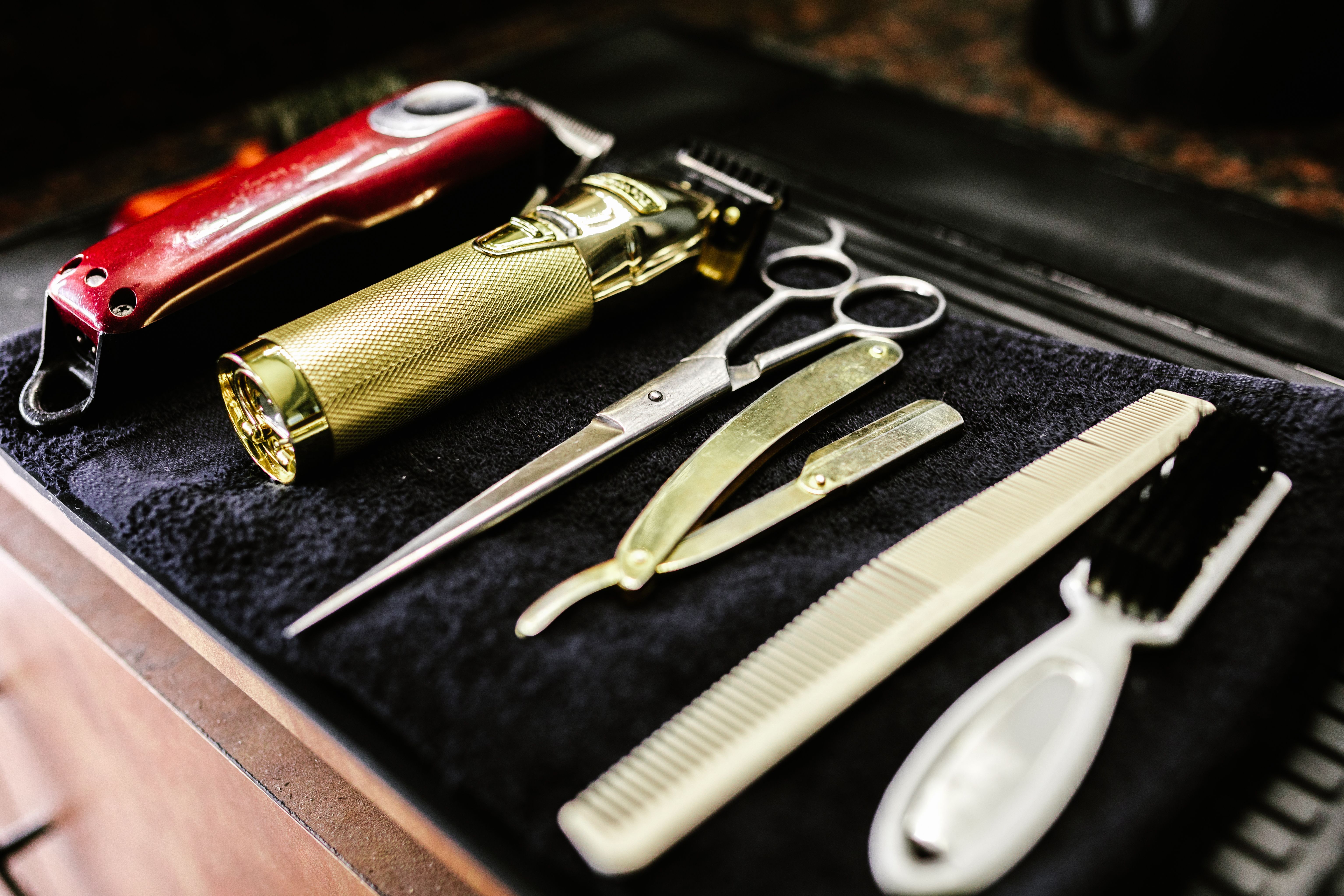 Barbershop tools including trimmers, scissors and razors arranged on a counter