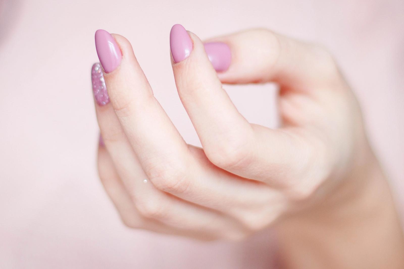 Close-up of a hand with a glossy pink manicure