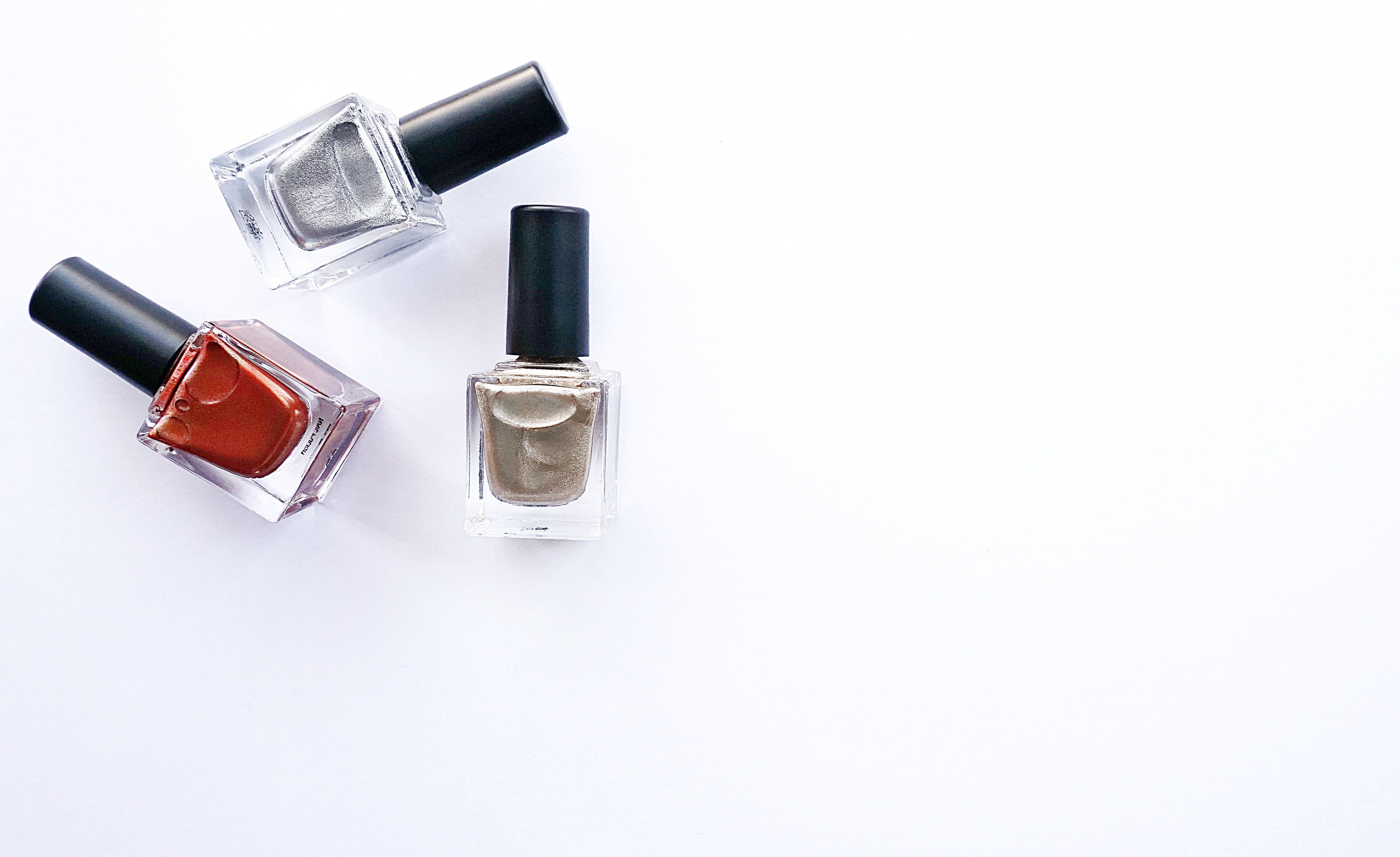 Assorted nail polish bottles arranged on a white surface