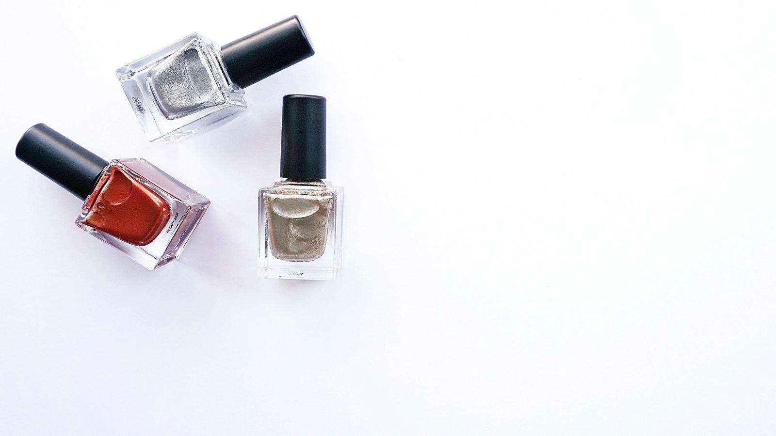 Assorted nail polish bottles arranged on a white surface
