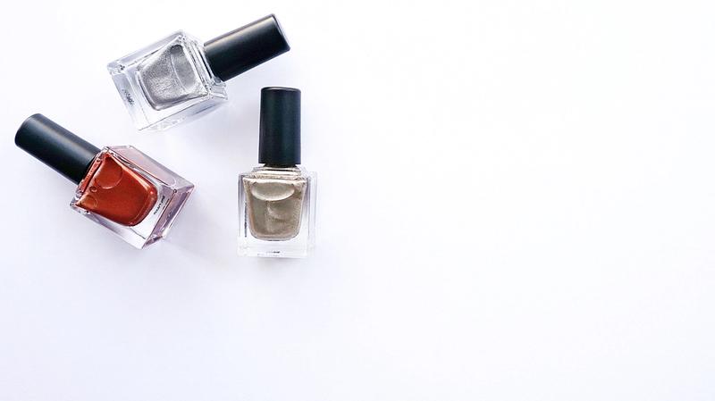 Assorted nail polish bottles arranged on a white surface
