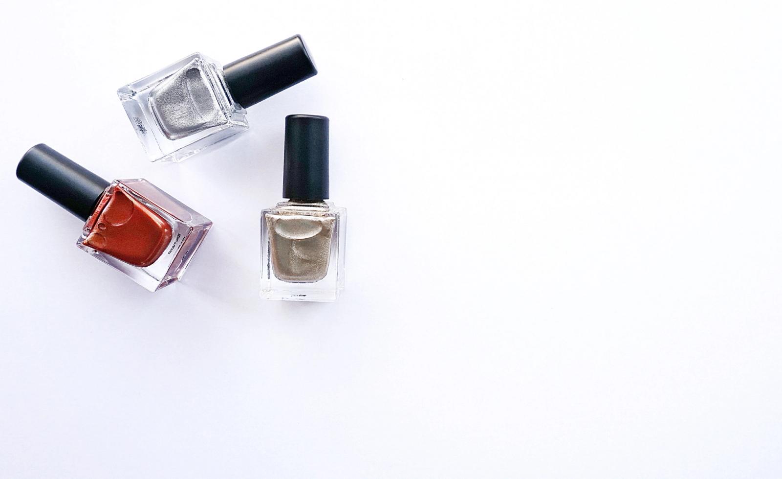 Assorted nail polish bottles arranged on a white surface