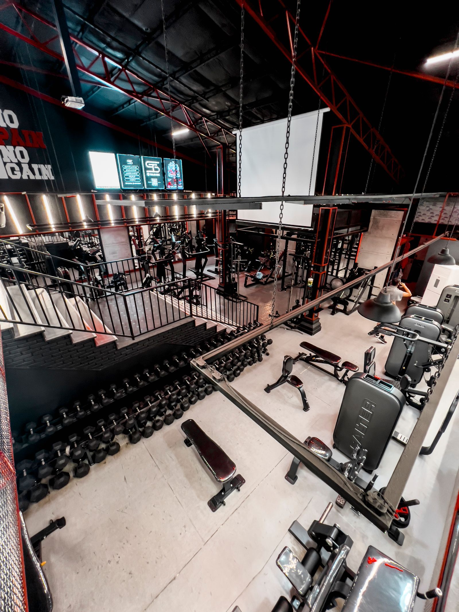 A modern gym floor lined with strength and cardio machines and no people