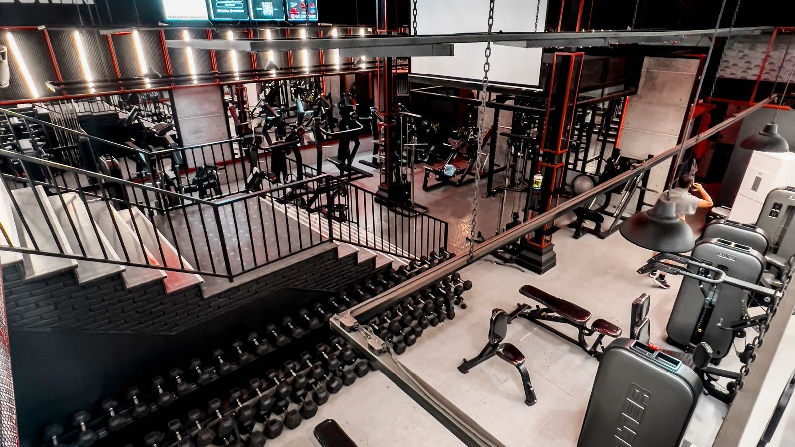 A modern gym floor lined with strength and cardio machines and no people