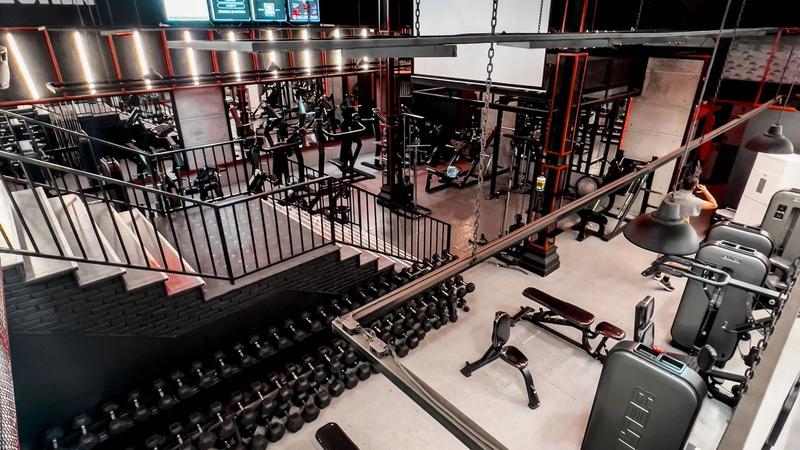 A modern gym floor lined with strength and cardio machines and no people