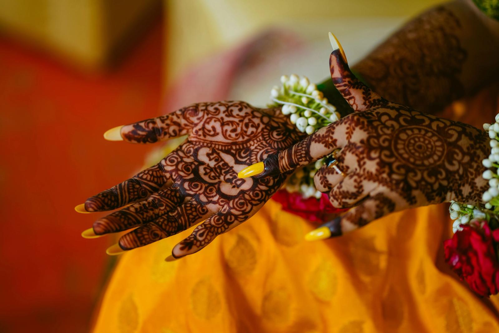 Intricate bridal mehndi henna designs on a bride's hands with fresh flowers