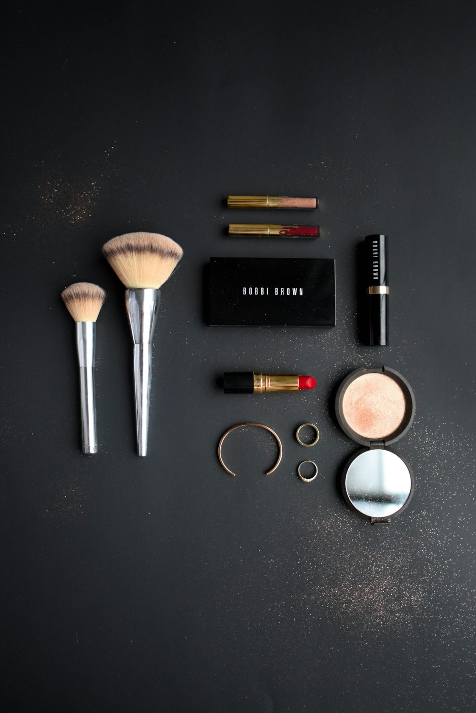 Assorted cosmetic palettes, highlighters, and beauty essentials on a salon vanity