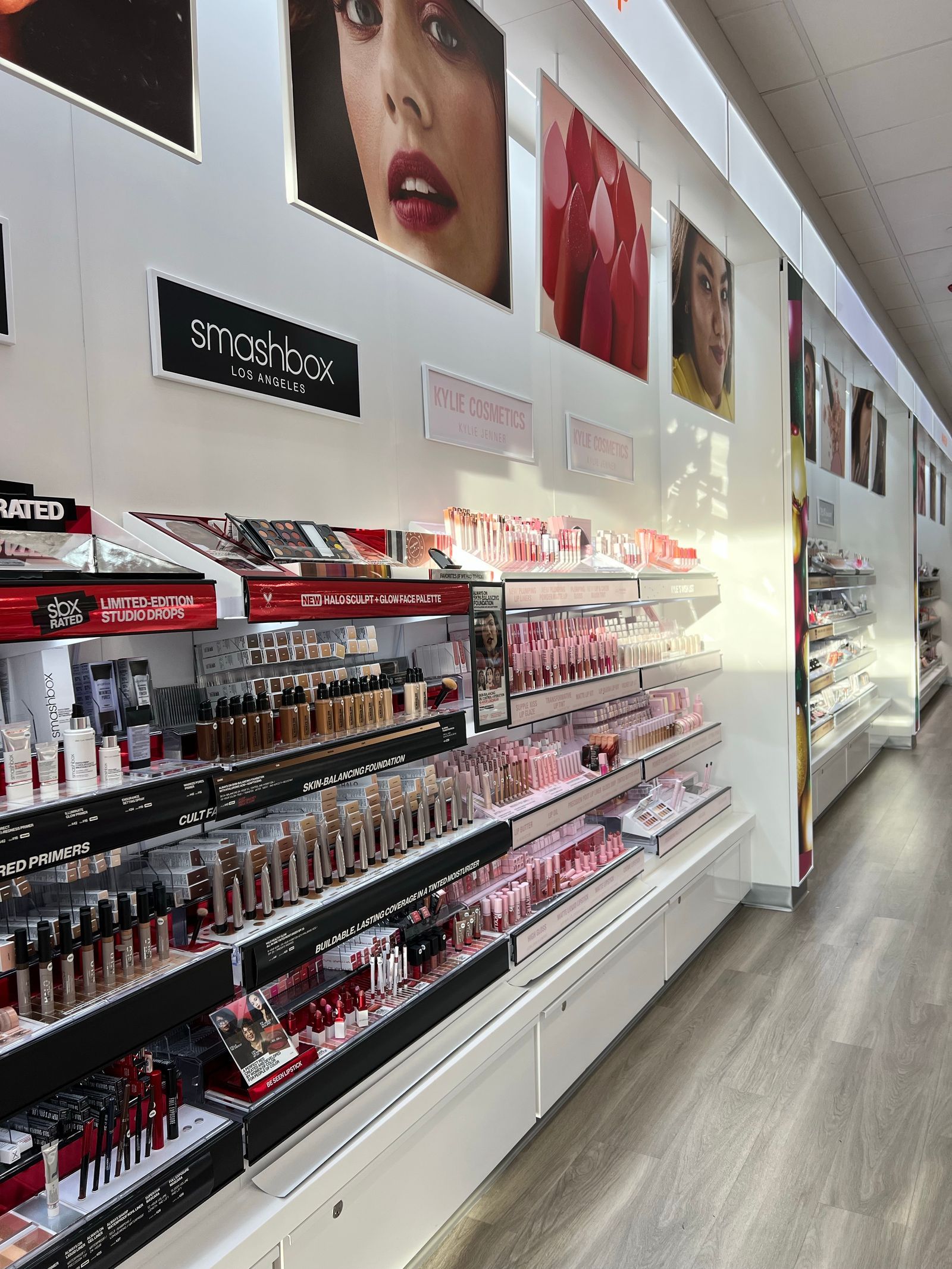Brightly lit makeup aisle with rows of cosmetics on display shelves