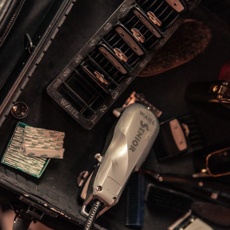 Top-down view of clean barber tools, scissors, and clippers on a workstation