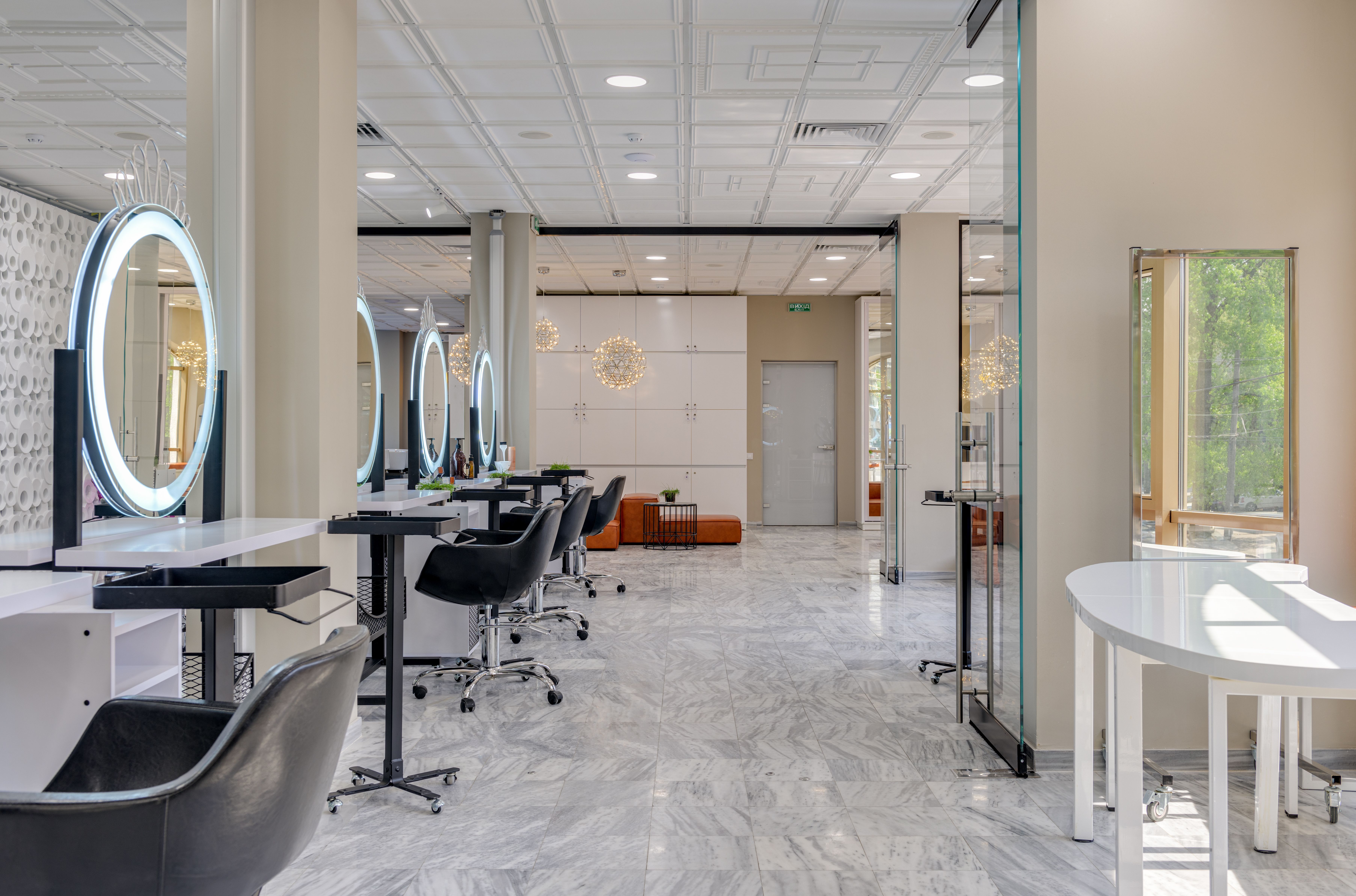 Empty modern salon interior with mirrors, styling chairs and pendant lighting