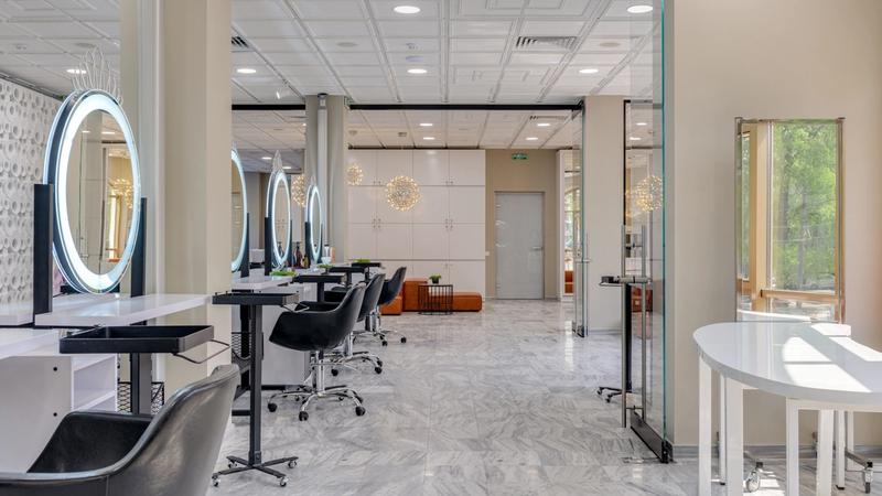 Empty modern salon interior with mirrors, styling chairs and pendant lighting