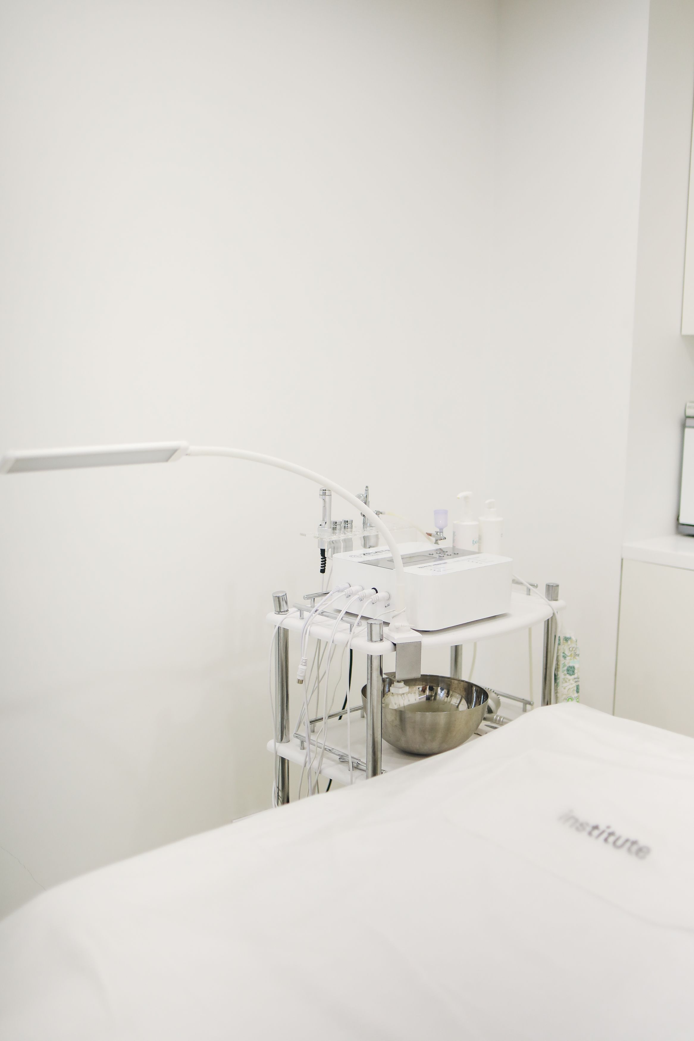 Professional skincare equipment arranged in a clean, minimalist clinic treatment room