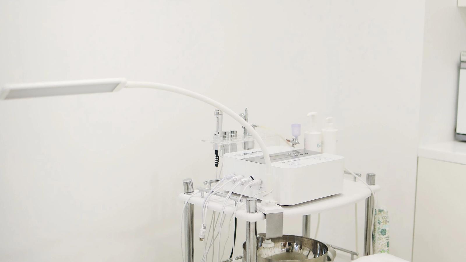 Professional skincare equipment arranged in a clean, minimalist clinic treatment room