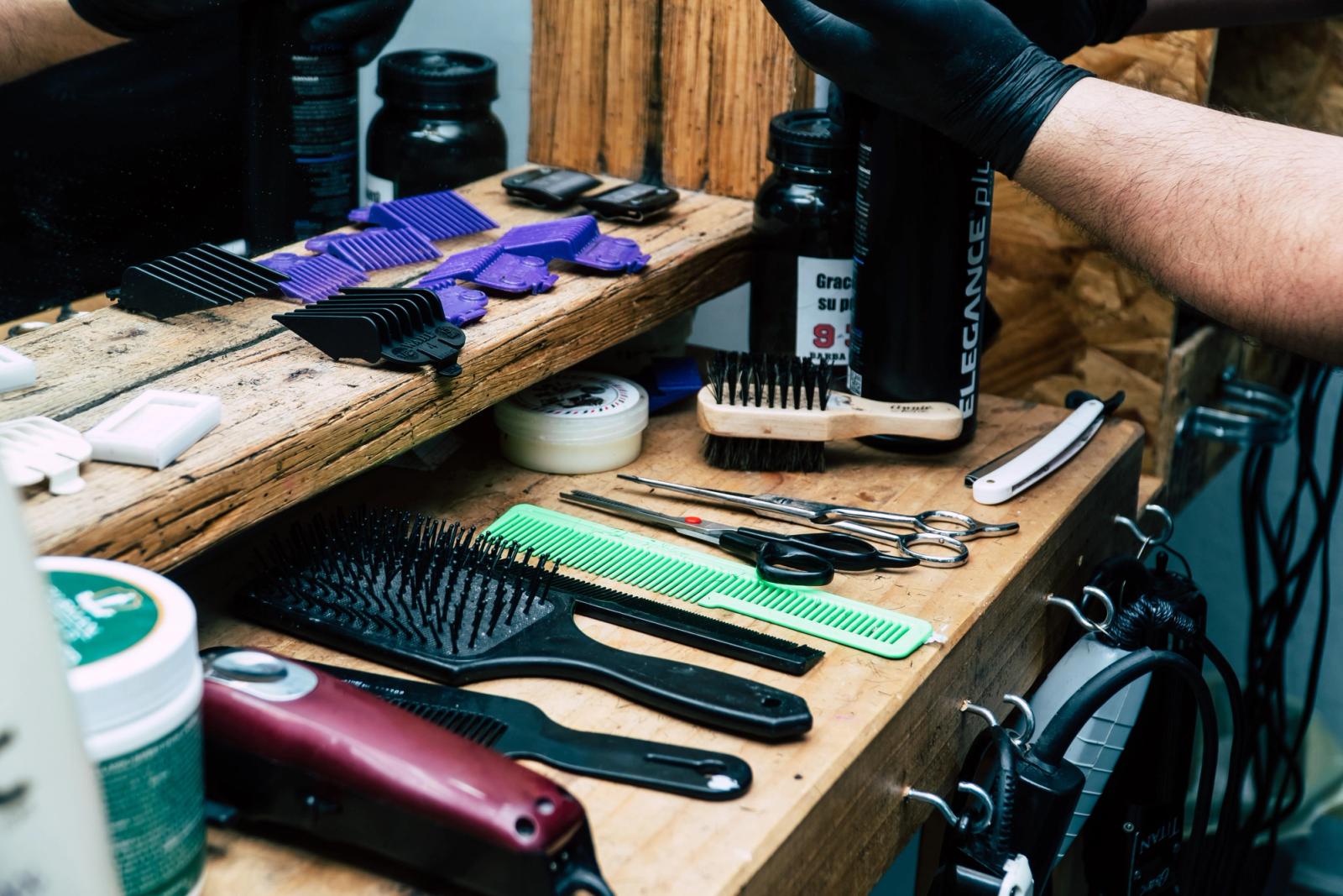 Barber scissors and combs arranged on a wooden barbershop counter
