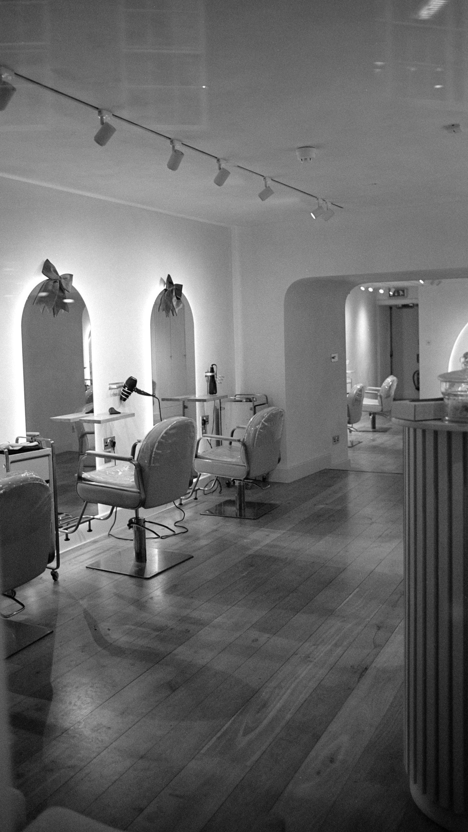 A modern hair salon interior with empty styling chairs and mirrors