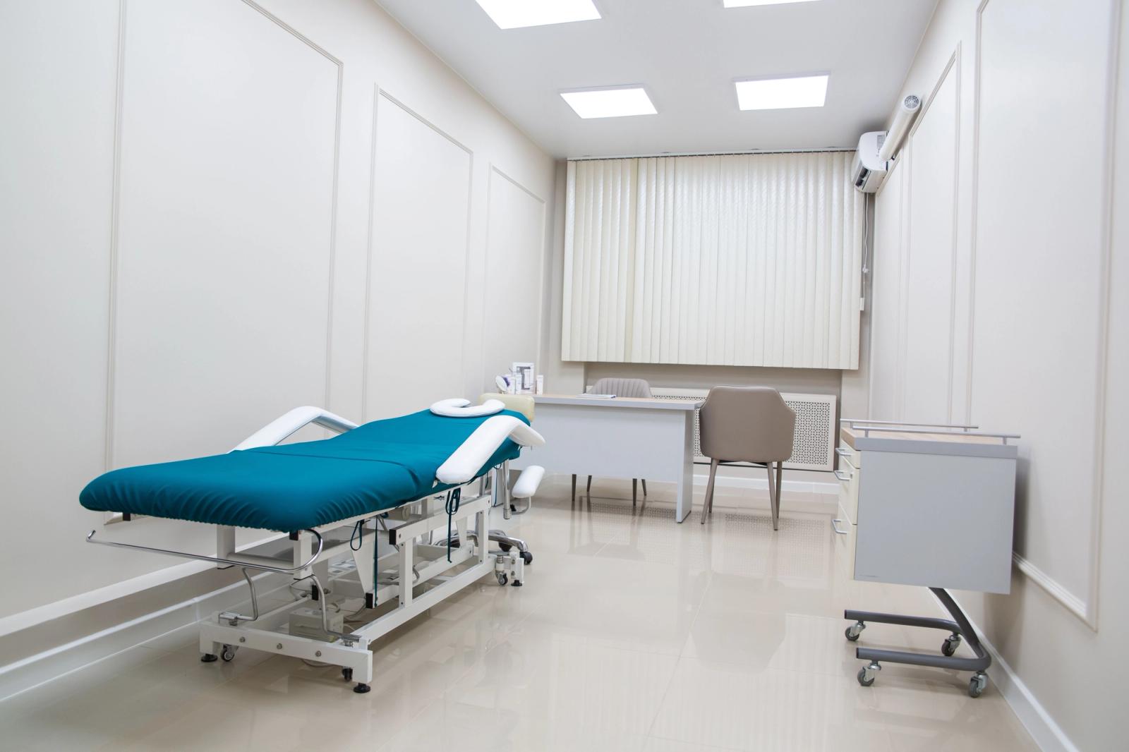 Clean, modern clinic treatment room with a bed